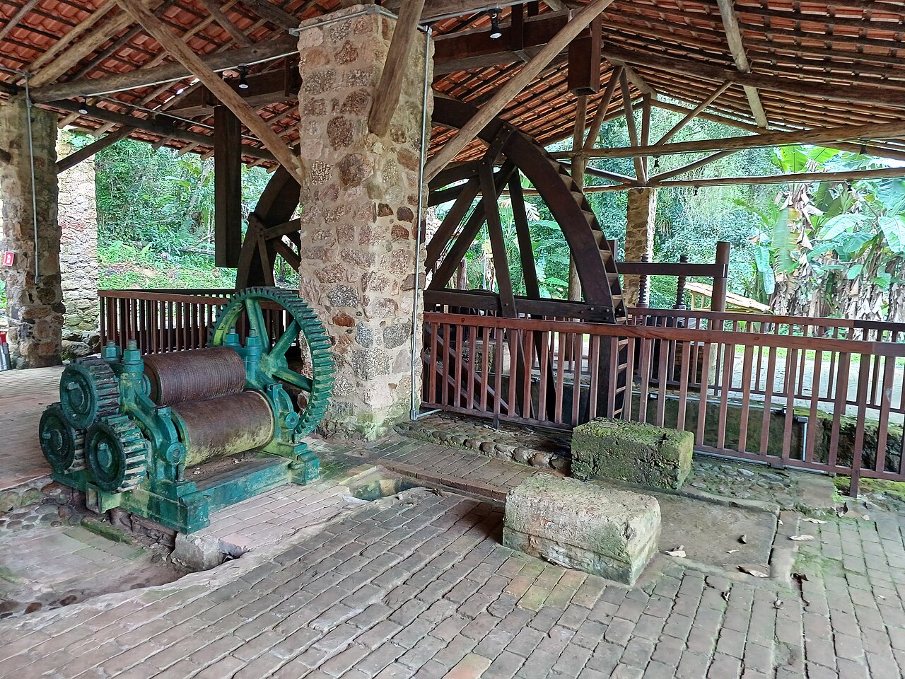 Roda de madeira e engenho da antiga Casa da Farinha, sob telhado de barro.